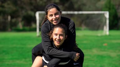 Girls soccer program Adelaide – two girls in Mastery Football Academy kit smiling on the pitch