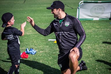 Mini Kickers soccer coach high-fiving young child at Mastery Football Academy Adelaide