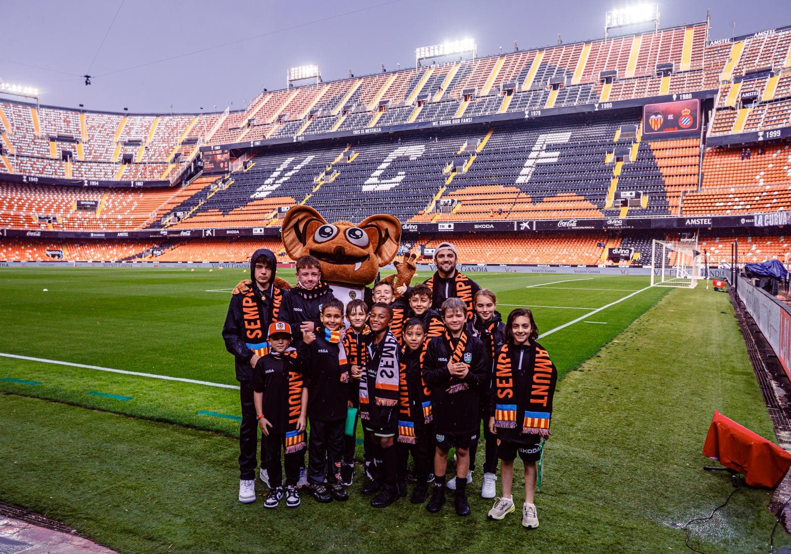 Mastery Football Academy players with Valencia CF mascot on the Mestalla Stadium pitch during the Spain Pathway tour